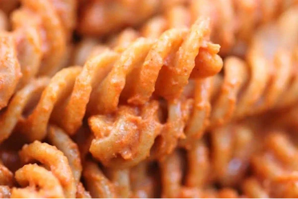 Close-up of whole-grain einkorn fusilli coated in smooth smoky tomato sauce