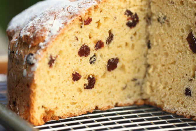 Close-up cross-section of Einkorn Irish soda bread showing dense crumb studded with raisins on a cooling rack