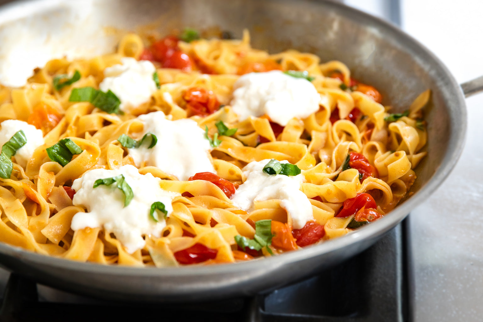Tagliatelle with cherry tomatoes and burrata in a panTagliatelle with cherry tomatoes and burrata in a panTagliatelle with cherry tomatoes and burrata in a pan